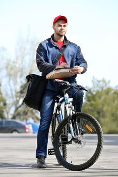 Young man with bike delivering pizza