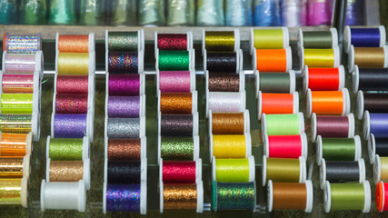  Expositor con carretes de hilo o sedal de distintos colores para fabricar anzuelos de pescar en la pesca con mosca ahogada