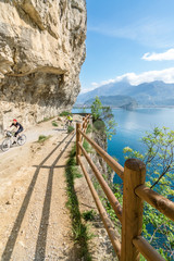 Fototapeta na wymiar Cyclists run through the trail of Ponale in Riva del Garda, Ital