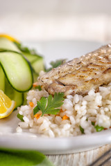 Healthy fish fillet on rice with zucchini