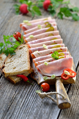 Deftige Wurstbrotzeit mit Bierschinken und Paprikawurst rustikal mit frischem Landbrot serviert - Slices of Bavarian sausages on a rustic wooden board © kab-vision