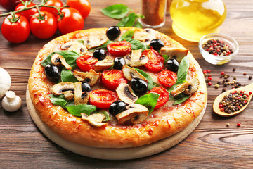 Delicious tasty pizza with ingredients on wooden table
