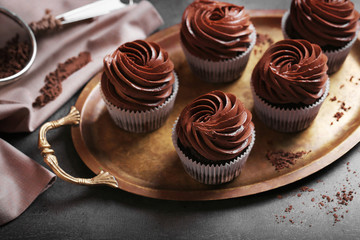 Chocolate cupcakes on a tray over grey background, close up