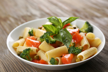 Plate of pasta with salmon and broccoli on table closeup
