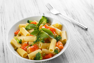 Plate of pasta with salmon and broccoli on table closeup