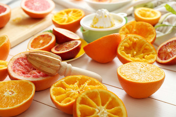 Juicing delicious oranges on white wooden table