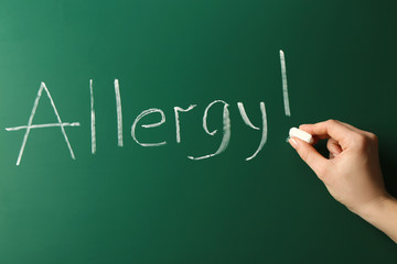 Allergy food concept. Hand with chalk writing on blackboard