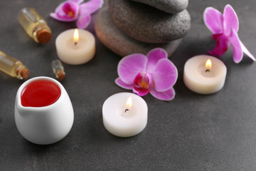 Beautiful spa set with massage oil and orchid on the table, close up