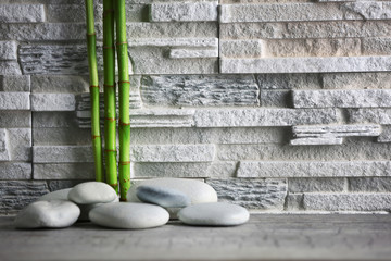 Composition of spa pebbles and bamboo on grey wall background