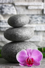 Fototapeta na wymiar Beautiful composition of pebbles, orchid and bamboo on grey background, close up