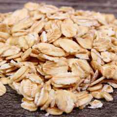 Heap of oat flakes on wooden background