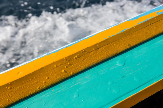 long tail boat gunnel with wet drop water on blurred waving back