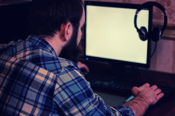 male behind computer with headphones