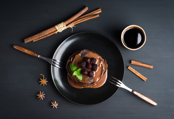 Stack of pancakes with fresh blackberries and chocolate syrup