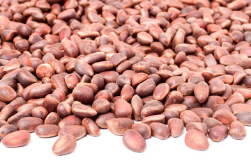 unpeeled pine nuts on a white background