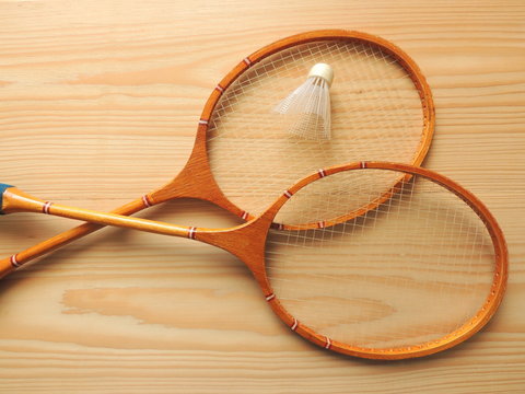 Sports equipment badminton rackets and  shuttlecock on a wooden Board.
