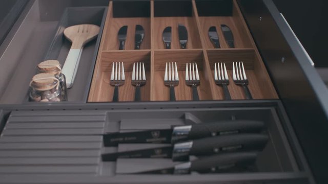 Luxury kitchen drawer with silverware closing in slow motion