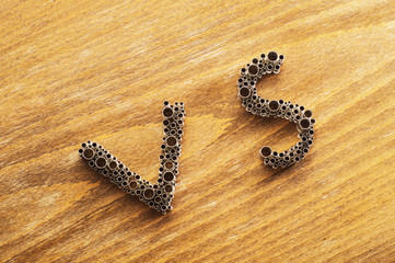 The concept of choice. Letters VS on wooden background
