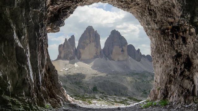 tre cime di lavaredo peaks as seen from inside a cave where soldiers use to sleep during the second or first world war