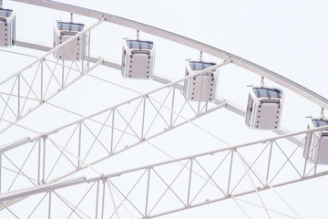 View on part of ferrsiwheel atractions in city park against sky