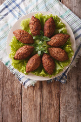 Arabic cuisine: meat appetizer kebbeh close-up on a plate. vertical top view
