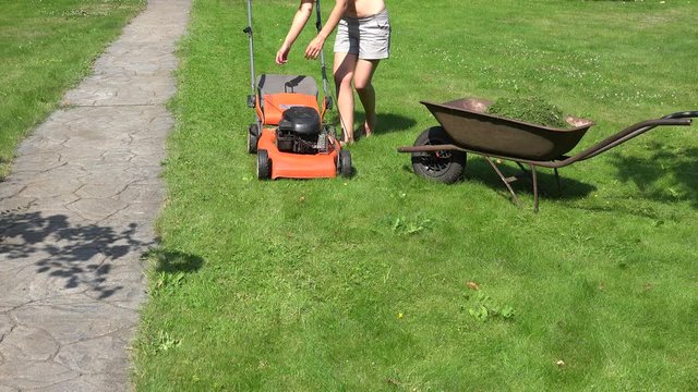 Female farmer start lawn mower and cut grass. 4K