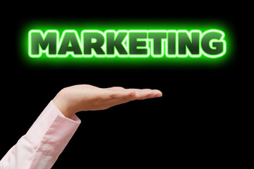 Business woman hand cupped holding the word MARKETING with green neon light