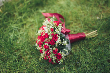 Bouquet of beautiful flowers and greenery is on the green grass