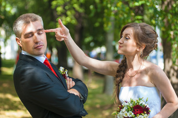 Bride and groom having fun on a walk in the park