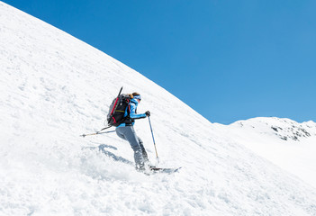 Female skier tackling a steep slope.