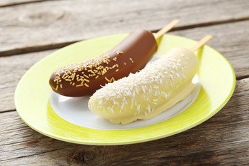 Banana covered in chocolate on a grey wooden table