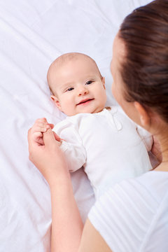 Рappy mother with baby on the bed.Smiling,laughing, happiness,p