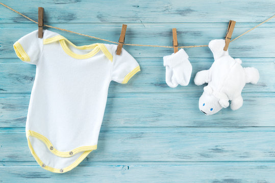 Baby clothes and white bear toy on a clothesline