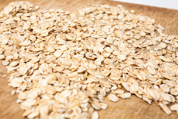 Raw oats wooden cutting board  background.