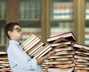 boy carrying books at the library