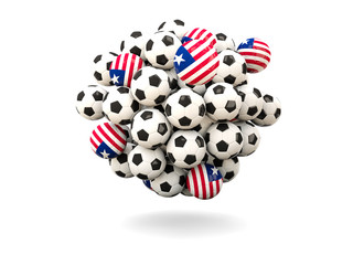 Obraz premium Pile of footballs with flag of liberia