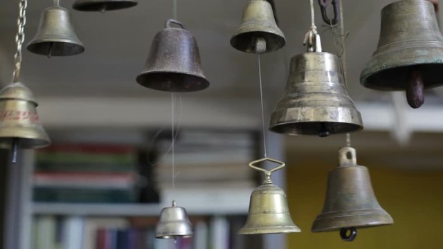 The swinging of many suspended metal bells in the room