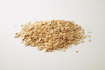 Healthy diet rolled oats isolated on white in center, prepared for cooking muesli for breakfast, side close focus view