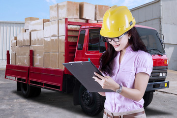 Woman working with delivery truck at factory