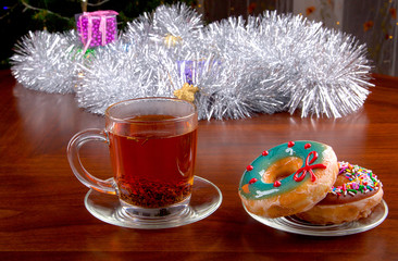 Donuts and cup of tea on Christmas background