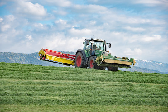 Landwirtschaft im Allgäu, Schlepper mit Kreiselmäher mäht Gras 