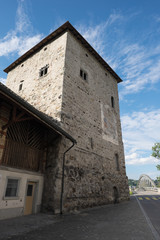 Fototapeta na wymiar Viereckiger alter Turm mit anbau und Brücke an der Strasse
