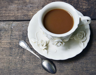 Сoffee with milk in vintage porcelain cup on old wooden background. Selective focus. 