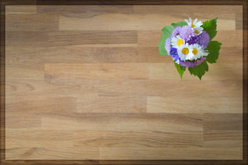 top view of wooden background with flowers  in corner for greeting card