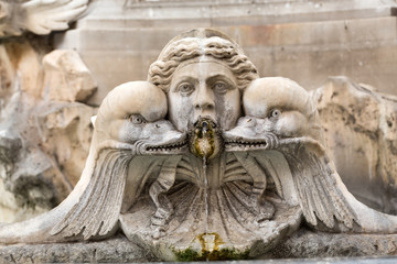 Fototapeta na wymiar Fragment of decorative fountain with sculptures of woman and dolphins. Italy, Rome. Piazza della Rotonda. Fontana del Pantheon