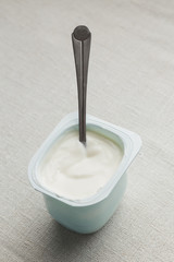Yogurts assortment in plastic bowls on light cloth background. Natural and fruit healthy, diet, gourmet dessert for granola breakfast. Sweet yoghurts closeup.