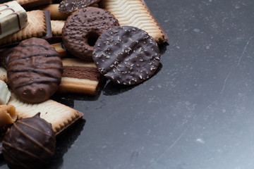 Cookies assorted on black background. Delicious morning snacks for breakfast, brunch and lunch. Appetizing, sweet and fast food.