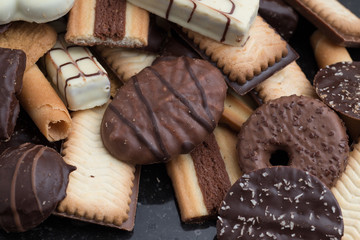 Cookies assorted on black background. Delicious morning snacks for breakfast, brunch and lunch. Appetizing, sweet and fast food.