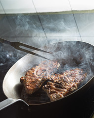Steak cooking on grille pan. Fresh, delicious, spicy meat on a kitchen with copy space closeup