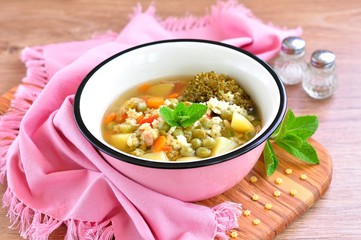 Soup of the rabbit meat with broccoli, green peas, carrots and pasta stars